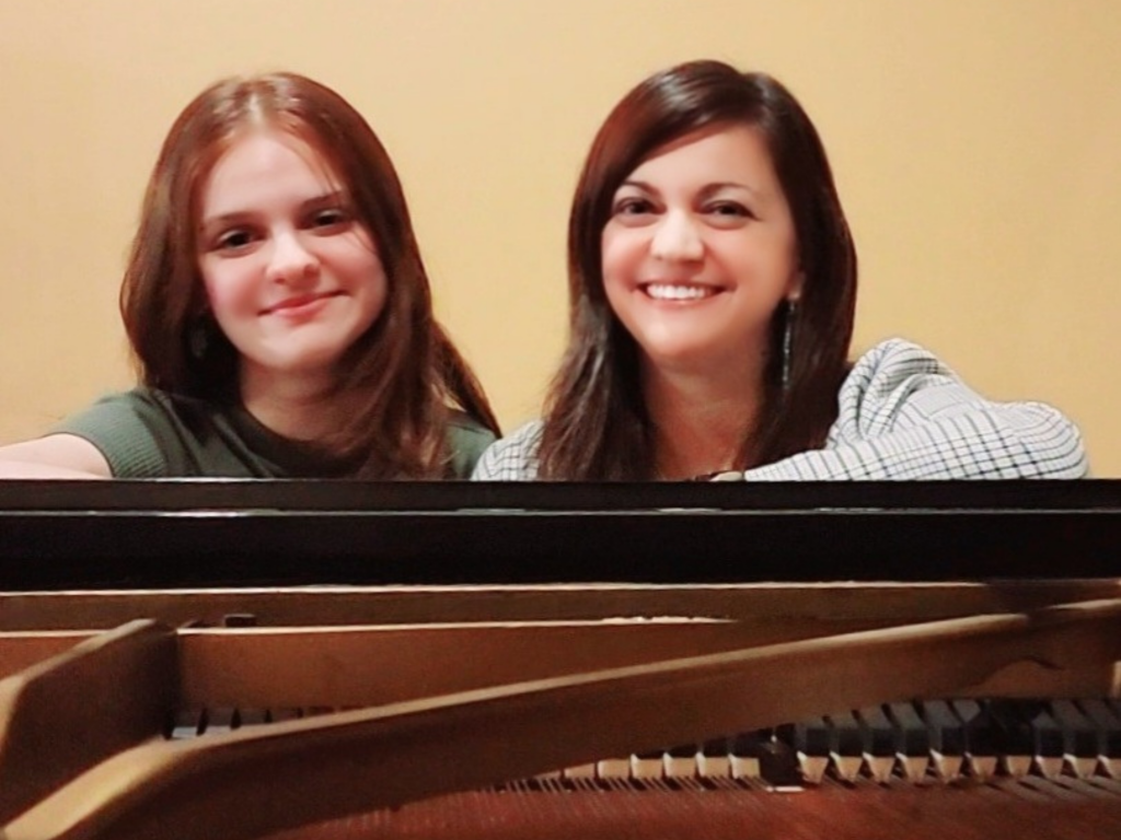 Elisa and Paola Plano sitting at a grand piano